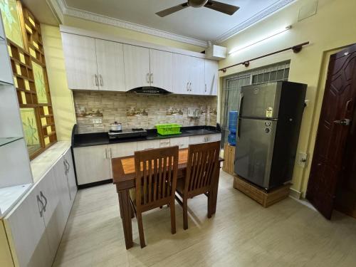 une cuisine avec une table en bois et un réfrigérateur dans l'établissement H&S Apartment, à Pokhara