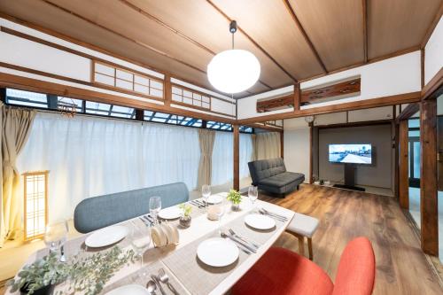 a dining room with a table and chairs and a television at いっぷく in Yokosuka