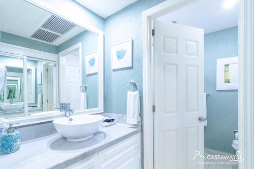 un bagno bianco con lavandino e specchio di Sonoran Spa N502 a Campo del Medio