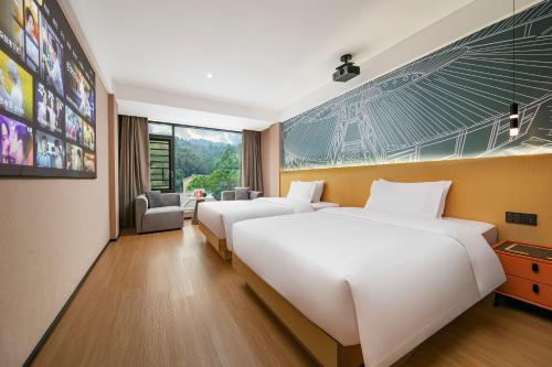 a hotel room with two beds and a large window at Yuntuji Homestay, Yongding Tulou Branch, Longyan in Bajia