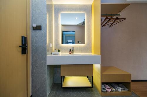 a bathroom with a sink and a mirror at Yuntuji Homestay, Yongding Tulou Branch, Longyan in Bajia