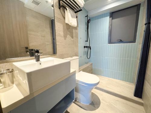 a bathroom with a white sink and a toilet at Bluejay Residences Kai Tak in Hong Kong