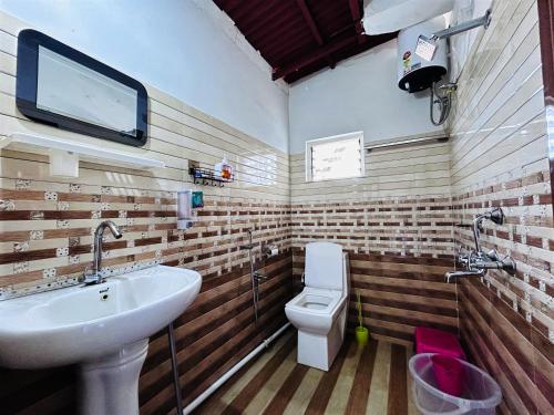 a bathroom with a sink and a toilet at Greenview108 in Kurseong