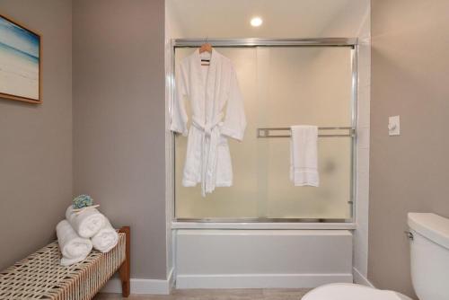 a bathroom with a shower with a white robe at Kaanapali Alii 385 · ALII 385 Corner 2BD OceanFront Dream Vacati in Kaanapali