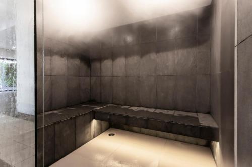 eine Dusche mit einer Bank in einer Duschkabine in der Unterkunft 2Bbr Apt SouthYarra Steps from Chapel St TF92125 in Melbourne