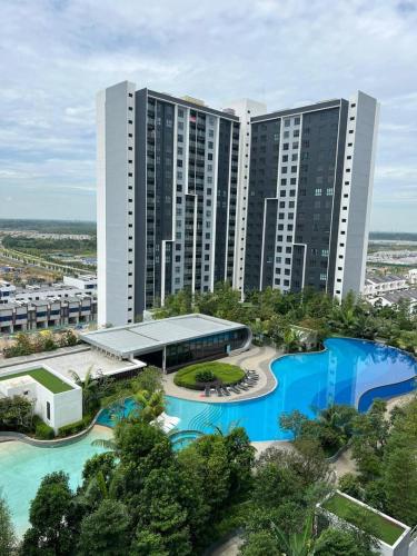 an aerial view of a large building with blue pools at Han's Homestay by RH Splash Mania at Mayabay Residences, Gamuda Cove in Pulau Kempas