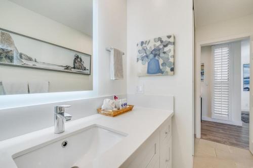 a white bathroom with a sink and a mirror at Wailea Ekahi 21A · WEK 21A Remodeled Wailea Condo Pool AC Near B in Wailea