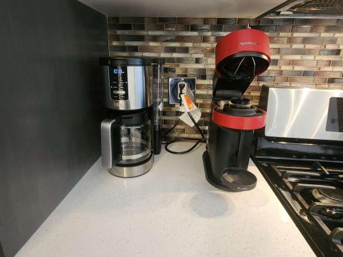 a coffeemaker and a coffee maker on a counter at Modern Family Home with guest heat garage, Pet-Friendly!- NO BASEMENT in Edmonton