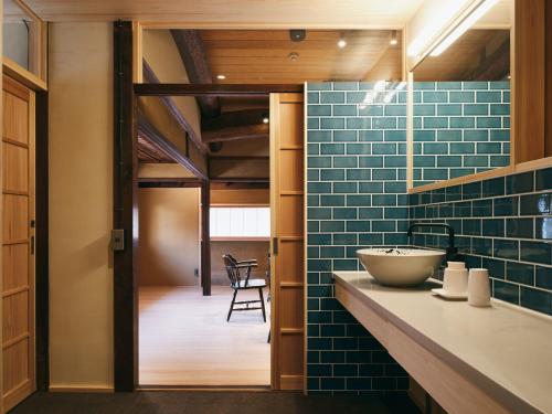 a bathroom with blue tile and a sink at 宿 -Shuku- in Inuyama