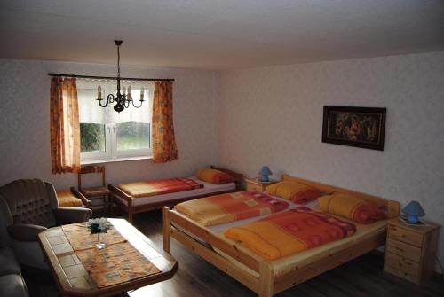 a bedroom with two beds and a table at Wohnung In Beliebtem Gästehaus Mit Fahrradverleih in Windeby