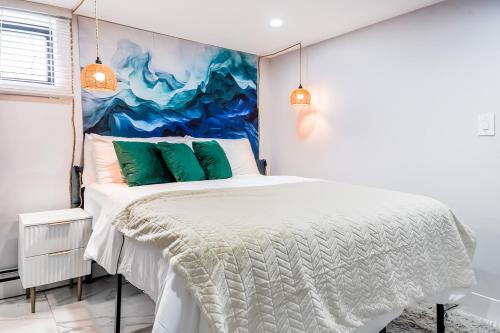 Un dormitorio con una cama blanca con un cuadro en la pared. en The Hideaway Suite, en Bellerose Terrace