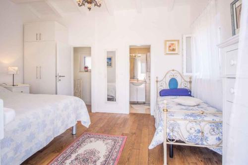 a white bedroom with a bed and a bathroom at Holiday home in Vrbnik - Insel Krk 13634 in Vrbnik