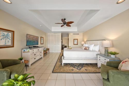 Un dormitorio con una cama y un ventilador de techo. en Eldorado L202 · EL L202 Updated Condo with Beachfront Cabana, en Kahana
