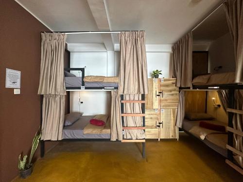 a room with three bunk beds in a room at Beyond Nomad Luxury Hostel in Ella