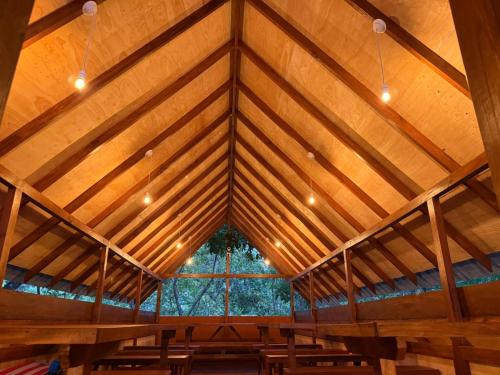 a room with a wooden ceiling with a large window at Mango Tree Villa in Sigiriya