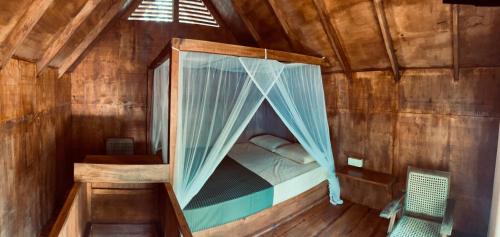 a bedroom with a canopy bed in a wooden cabin at Mango Tree Villa in Sigiriya