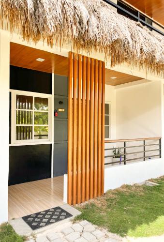 une maison tropicale avec un toit de chaume dans l'établissement Zand Pointe Suites, à General Luna