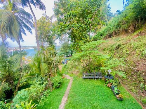 una colina de hierba con un banco y vistas al agua en Talalla Wonder View, en Talalla South