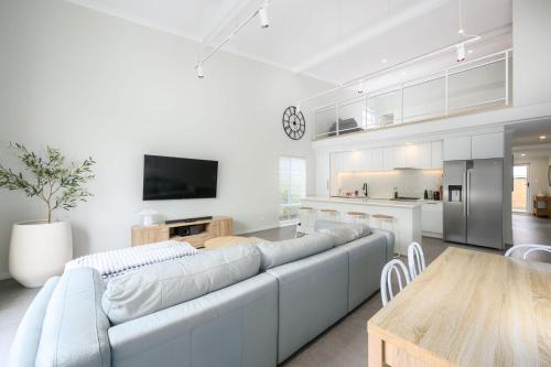 a white living room with a large couch and a table at Coastal Comfort in Golden Bay in Secret Harbour