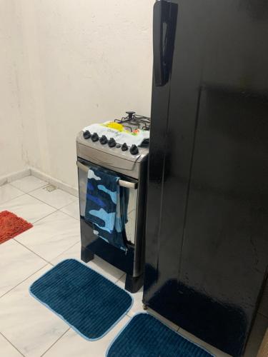 einen Herd in einer Küche neben einem Kühlschrank in der Unterkunft Kitnet Dream House 4 in Bayeux