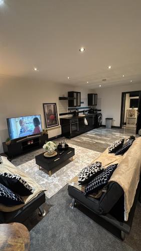 a living room with two beds and a flat screen tv at Huddersfield City Center Retreat - New Images coming soon in Huddersfield