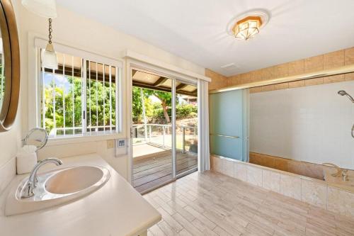 a bathroom with a sink and a large mirror at Hale Kalapu · Large Home 180° Ocean Views Walk2Beach Hale Kalapu in Kaanapali