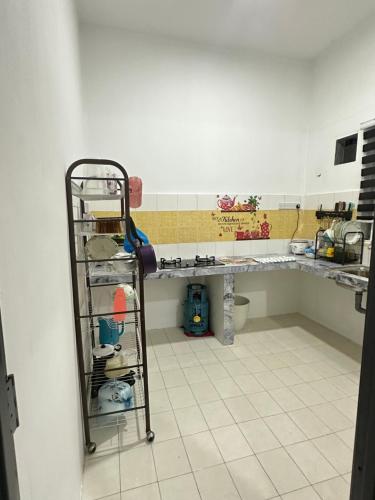 a kitchen with a sink and a counter with a shelf at Homestay Bandar Sejahtera in Pokok Sena