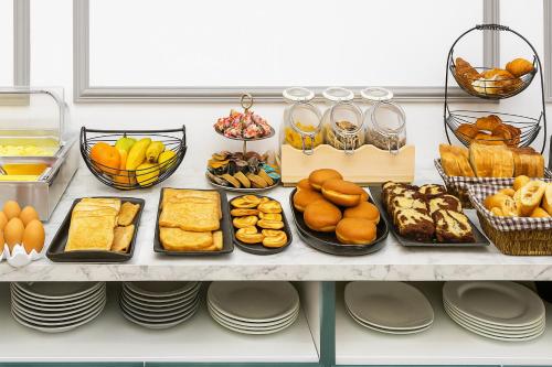 ein Regal gefüllt mit verschiedenen Brot- und Gebäcksorten in der Unterkunft Hotel Arc Paris Porte d'Orléans in Montrouge