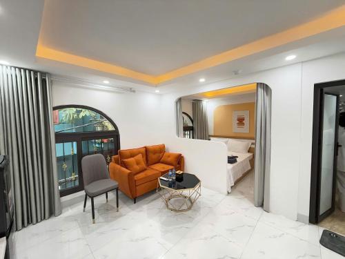 Una habitación de hotel con una cama, un sofá y una silla. en 25 House 298 Ngoc Lam - Long Bien bridge, en Hanói