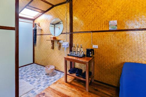 Ban Pha Saeng LangにあるBansuanphutarnの部屋にテーブルと鏡があるバスルーム