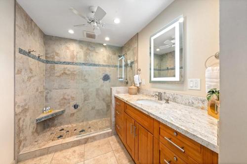 a bathroom with a large sink and a shower at Kulakane 310 · KK 310 Updated BeachFront 2BD w AC Pool in Kahana
