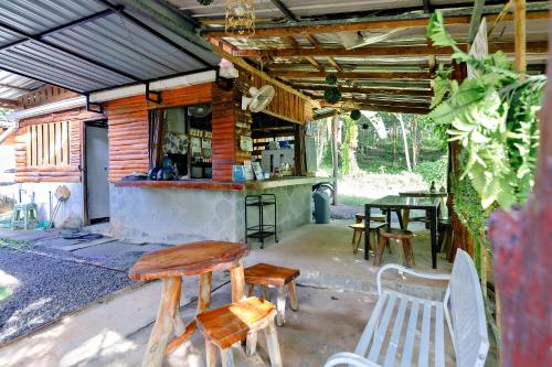 Ban Pha Saeng LangにあるBansuanphutarnの木製のテーブルと椅子が備わる屋外バー