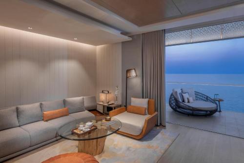 a living room with a couch and a view of the ocean at InterContinental Ras Al Khaimah Mina Al Arab Resort & Spa by IHG in Ras al Khaimah