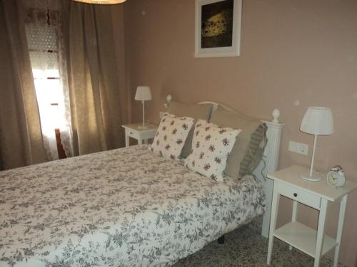 ヘレス・デ・ラ・フロンテーラにあるApartamento Centro Jerez Campanaのベッドルーム1室(枕、テーブル2台付)