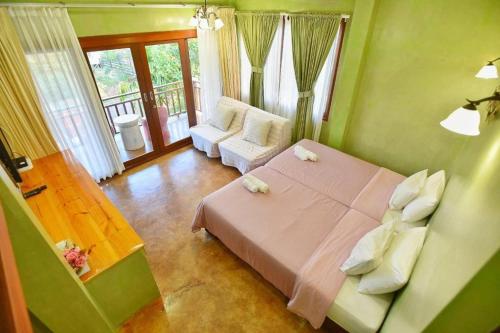 a bedroom with a bed and a balcony at Baan Parinda (Pompom Home) in Pran Buri