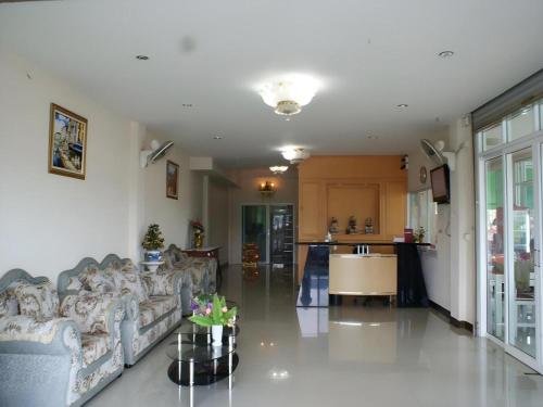 a living room with a couch and a kitchen at Crystal Place Buayai in Bua Yai