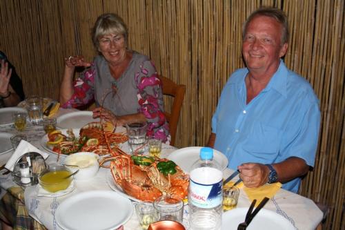 a man and woman sitting at a table with a crab at Pension Askas in Aegiali