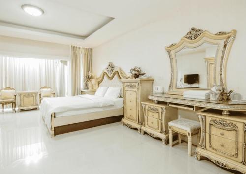 a bedroom with a bed and a mirror and a piano at Crystal Place Buayai in Bua Yai