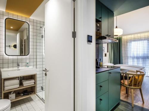 a bathroom with green cabinets and a sink at Aparthotel Adagio access Hamburg in Hamburg