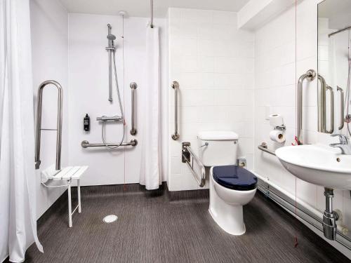 a bathroom with a toilet and a sink at ibis budget London Heathrow Central in Hounslow