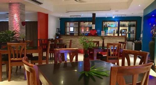 a restaurant with a table and chairs and a bar at Victoria Palms Hotel in The Domain