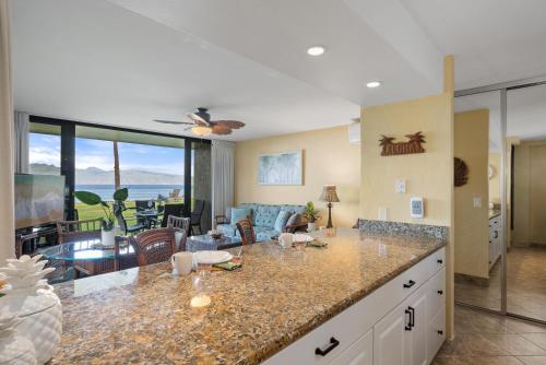 a kitchen with a counter top and a living room at Papakea L101 · PK L101 Maui Ground-Floor Condo with Ocean Views in Honokowai
