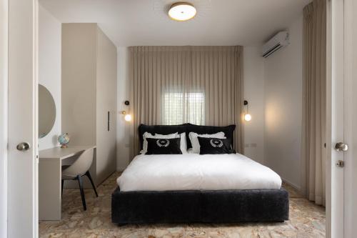 a bedroom with a large bed and a desk at The charm of Jerusalem in Jerusalem