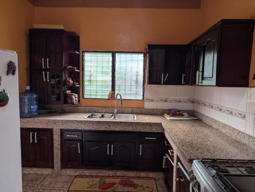 Una cocina con gabinetes negros y un fregadero. en Alojamiento premium, excelente para grandes grupos o familias, en Cruce de Veragua