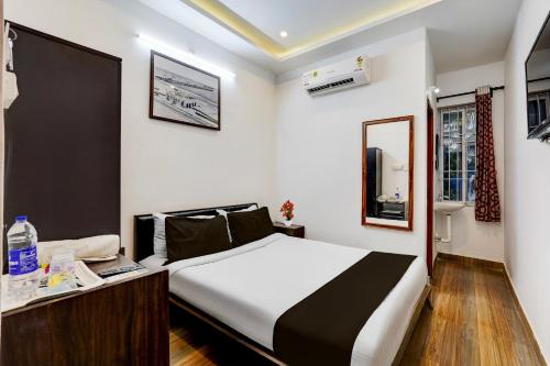 ein Schlafzimmer mit einem Bett und einem Schreibtisch in einem Zimmer in der Unterkunft Super Townhouse Auroville Beach Formerly De Heritage in Kottakupam