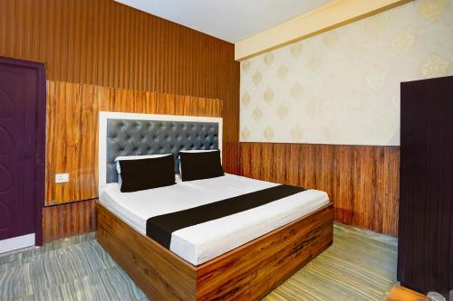 a bedroom with a large bed in a room at Super Hotel O Dehradun City Centre in Dehradun