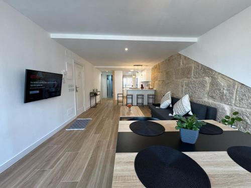 a living room with couches and a stone wall at CENTRO VIGO Apartamento reformado, AVE-VIALIA - muy céntrico 5PAX in Vigo