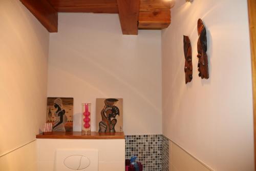 baño con estante y pinturas en la pared en Coeur de Vogüé, en Vogüé
