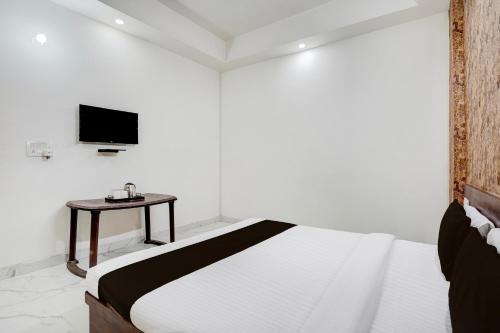 a white bedroom with a bed and a table at Collection O Palwal-Aligarh Crossway Formerly Hotel Kadamb in Palwal