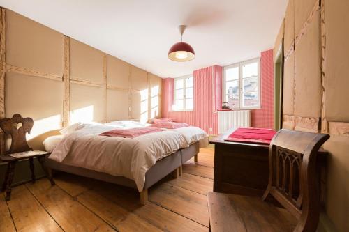 a bedroom with a large bed and a wooden floor at Les Appartements Saint Nicolas in Colmar